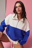 Woman wearing a blue and white jacket against a pink background