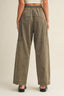 Person wearing olive green wide-leg pants on a beige background
