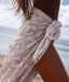 Person wearing a patterned sarong by the ocean
