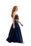 Woman in a blue dress walking on a sidewalk with people in the background.
