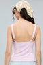Woman wearing a light pink tank top and a decorative headscarf on a gray background