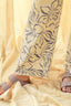 Beige fabric with floral pattern and sandals on a matching fabric background