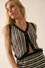 Woman wearing a black and white striped sleeveless top against a neutral background