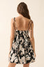 Woman wearing a black and white floral dress with thin straps on a beige background