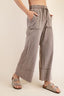 Person wearing light gray wide-leg pants on a beige background