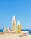 OSEA skincare products on sand with a blue sky background