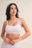 Woman wearing a light pink checkered top and skirt on a beige background