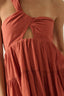 Close-up of a rust-colored dress with a knot detail on a plain background