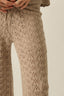 Beige knitted pants with a subtle pattern on a plain background