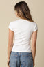 Person wearing a white t-shirt and blue jeans on a beige background