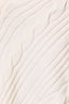 Close-up of a cream-colored cable-knit fabric texture with vertical and diagonal ribbed patterns.
