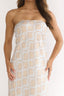 Woman wearing a strapless dress with a geometric pattern on a white background