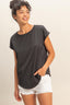 Woman wearing a black top and white shorts against a plain background