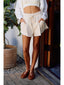 Person wearing a white outfit with shorts and a crop top, standing outdoors.