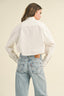 Person wearing a white shirt and light blue jeans with Levi's logo on a beige background