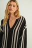 Woman wearing a black and white striped sweater on a plain background