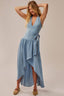 Woman wearing a light blue dress with a plain background