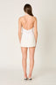 Woman wearing a white mini skirt on a plain background