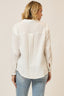 Woman wearing a white blouse and blue jeans on a beige background