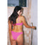 Woman in a pink bikini standing in a shower with tiled walls.