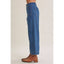 Person wearing blue jeans and brown boots on a plain background