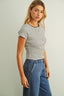Woman wearing a striped shirt and jeans against a plain background