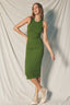 Woman wearing a green dress standing against a plain background