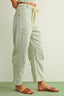 Person wearing light blue and white striped pants with a plain background