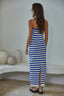 Woman wearing a blue and white striped dress standing in a minimalistic room.