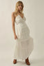 Woman wearing a white dress against a plain background