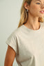 Woman wearing a beige t-shirt against a plain background