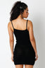 Woman wearing a black crochet cover up dress with a textured pattern on a white background