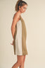 Woman wearing a two-tone dress with beige and white panels on a plain background