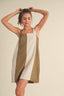 Woman wearing a sleeveless dress with a geometric color-block design on a beige background