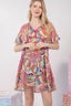 Woman wearing a colorful patterned dress against a white background
