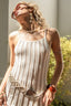 Woman wearing a light-colored dress with decorative elements outdoors