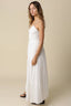 Woman wearing a white dress against a beige background