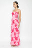 Woman wearing a pink floral strapless dress on a white background