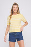 Woman wearing a yellow striped shirt and blue shorts on a white background