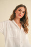 Woman wearing a white blouse against a beige background