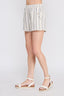 Person wearing white striped shorts on a light gray background