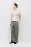 Woman wearing a white t-shirt and gray pants on a white background