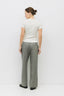 Woman wearing a white top and gray pants on a white background
