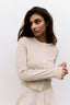 Woman wearing a striped sweater against a plain background