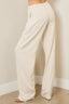 Beige wide-leg pants worn by a person against a plain wall.