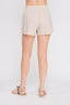 Beige shorts worn by a person on a white background