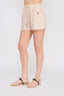 Beige shorts worn by a person on a plain background