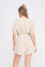 Woman wearing a beige romper on a white background