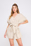 Woman wearing a beige romper on a white background