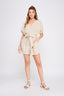 Woman wearing a beige romper on a white background